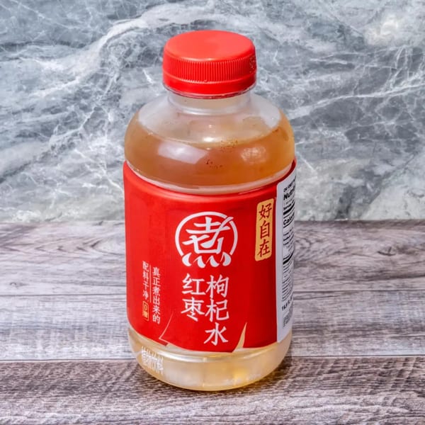 A plastic bottle of red jujube and goji berry drink with a red label and cap.